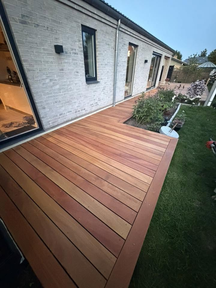 Træterrasse anlæg i mahogni langs husmur med bed og græsplæne – terrasse Sjælland